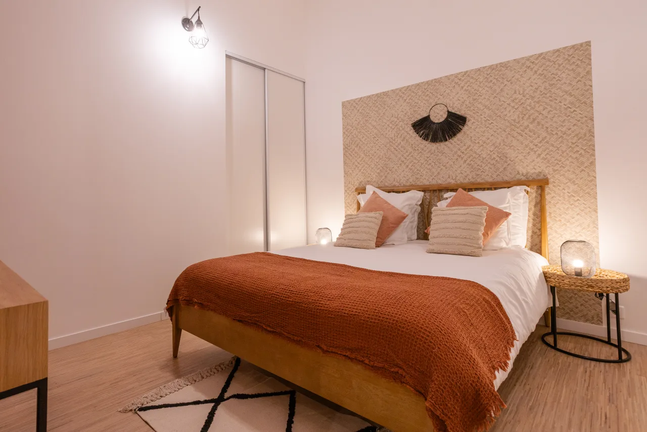 Loft La Vesée — chambre terracotta en lumière chaude du soir, lampe de chevet allumée