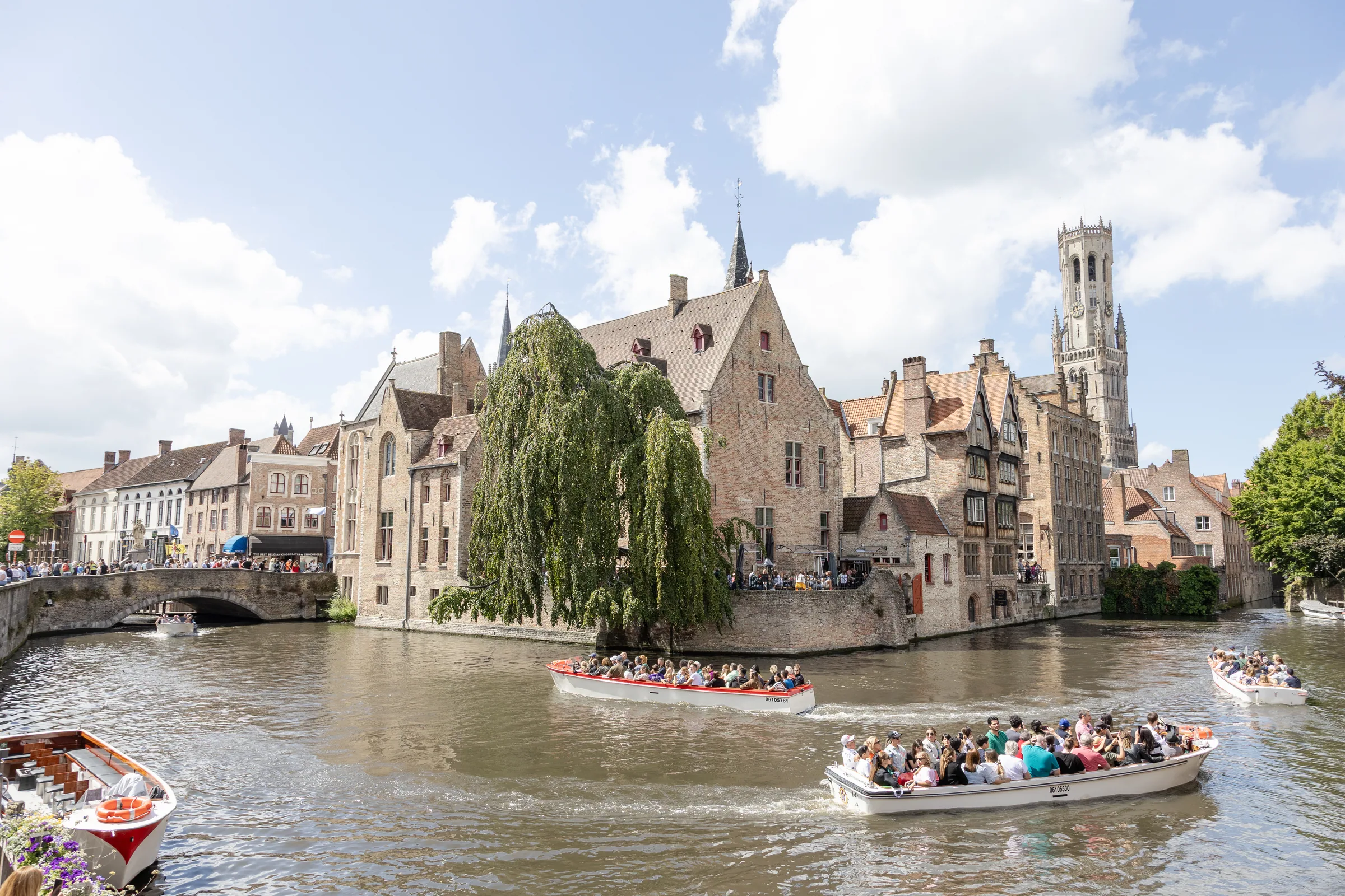 Bruges, canal bordé de maisons en briques avec bateaux de visite