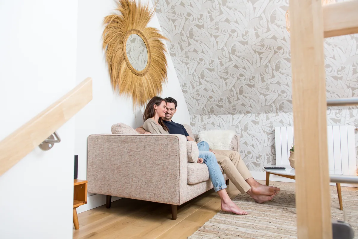 Maison La Vesée, l'appartement Alpinia, le salon, un couple installé dans le canapé, autre vue