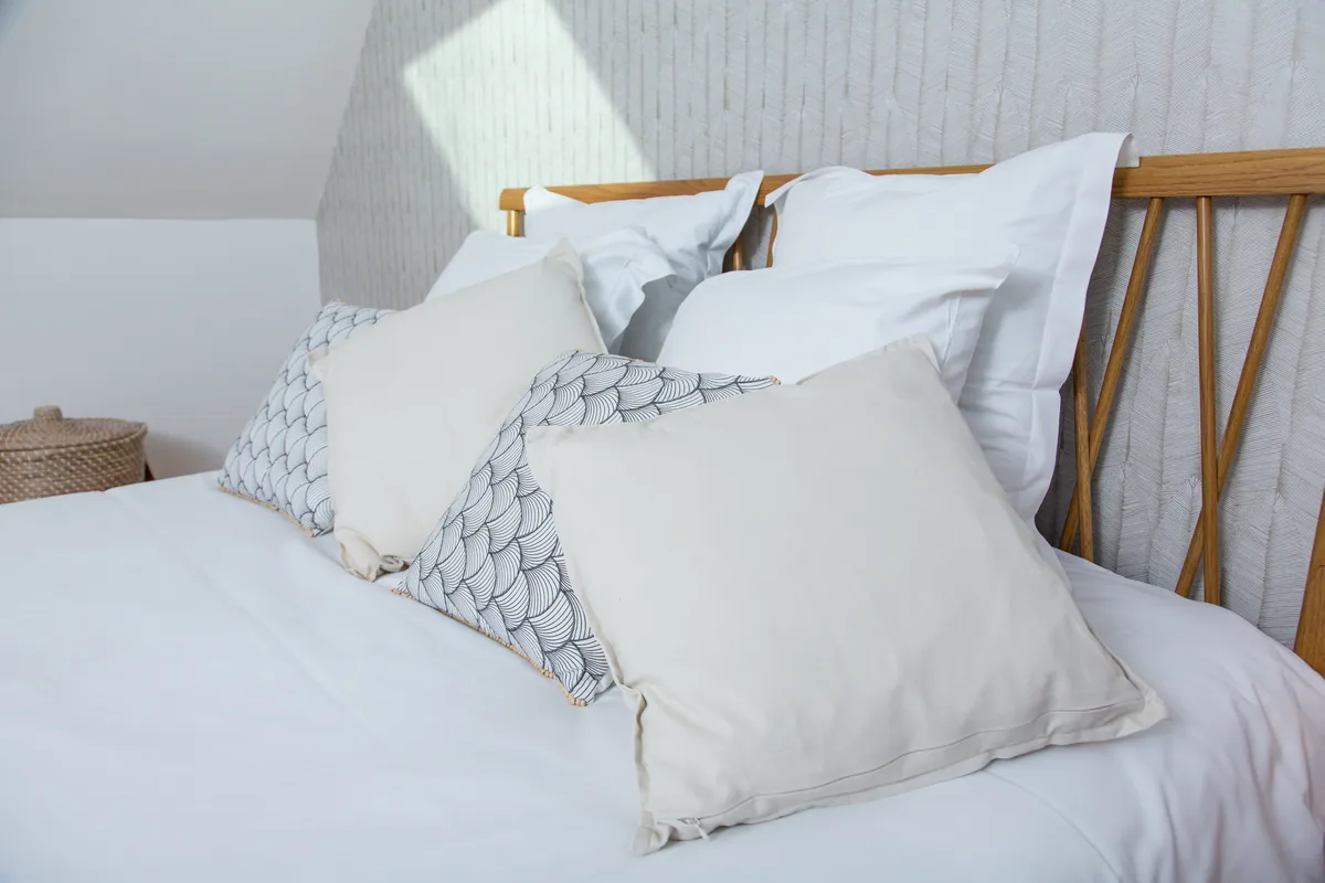 Maison La Vesée, l'appartement Alpinia, la chambre, gros plan sur les coussins du lit