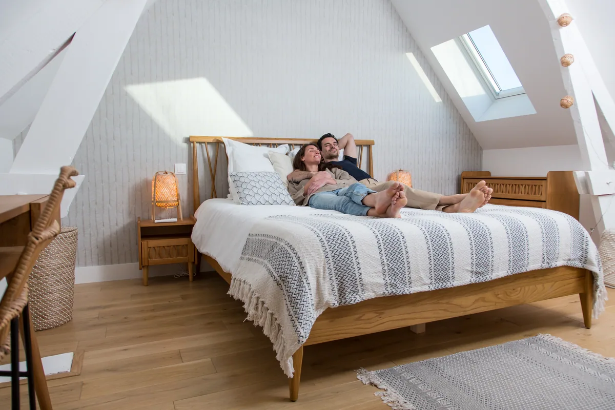 Maison La Vesée, l'appartement Alpinia, la chambre, un couple installé sur le lit en journée