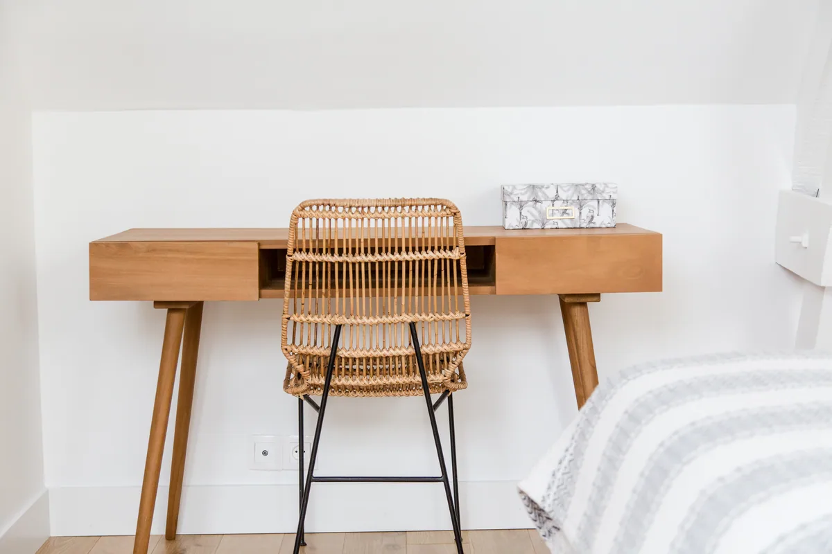 Maison La Vesée, l'appartement Alpinia, la chambre, le bureau en bois et la chaise en osier