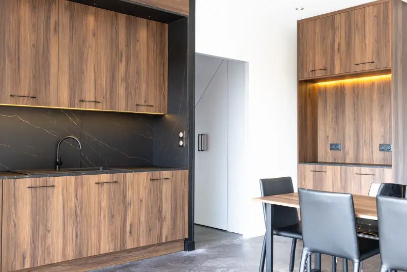 Maison La Vesée, l'Annexe, la cuisine créative, vue sur le coin évier et le meuble petit déjeuner, façade en noyer et plan de travail en marbre noir