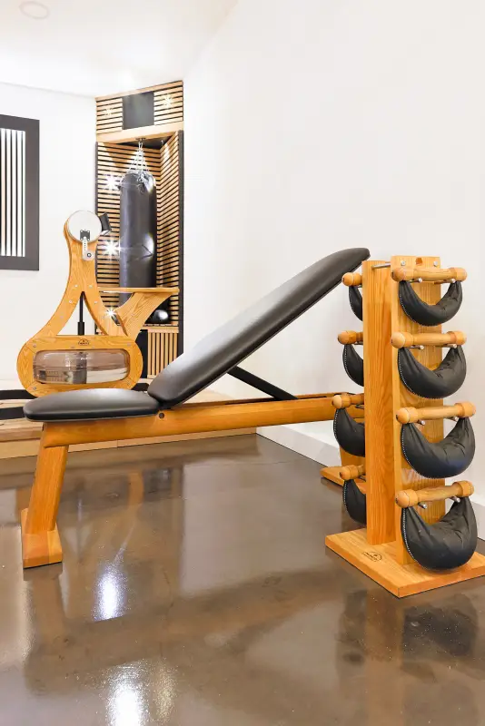 Maison La Vesée, l'Annexe, la salle de sports, le banc de musculation et les haltères SwingBell, le vélo à bras et le sac de frappe en arrière-plan