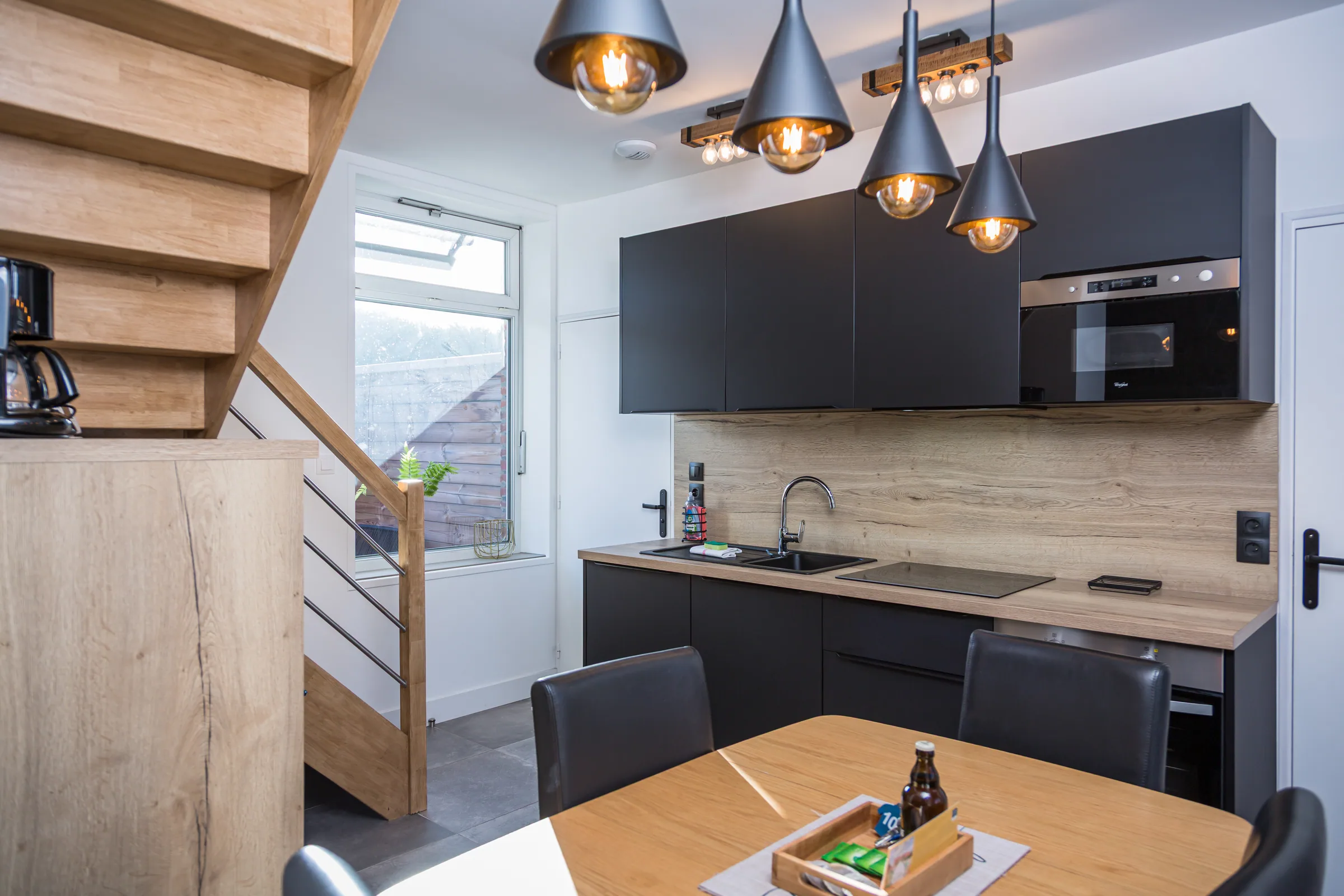 Maison La Vesée, l'appartement Heliconia, la cuisine vue d'ensemble avec la table chêne au premier plan