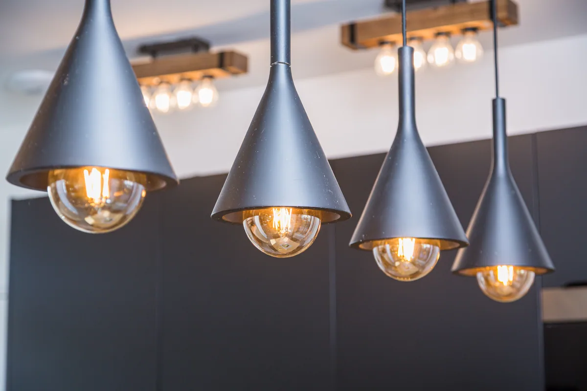 Maison La Vesée, l'appartement Heliconia, la cuisine, détail sur les luminaires en suspension noirs éclairés
