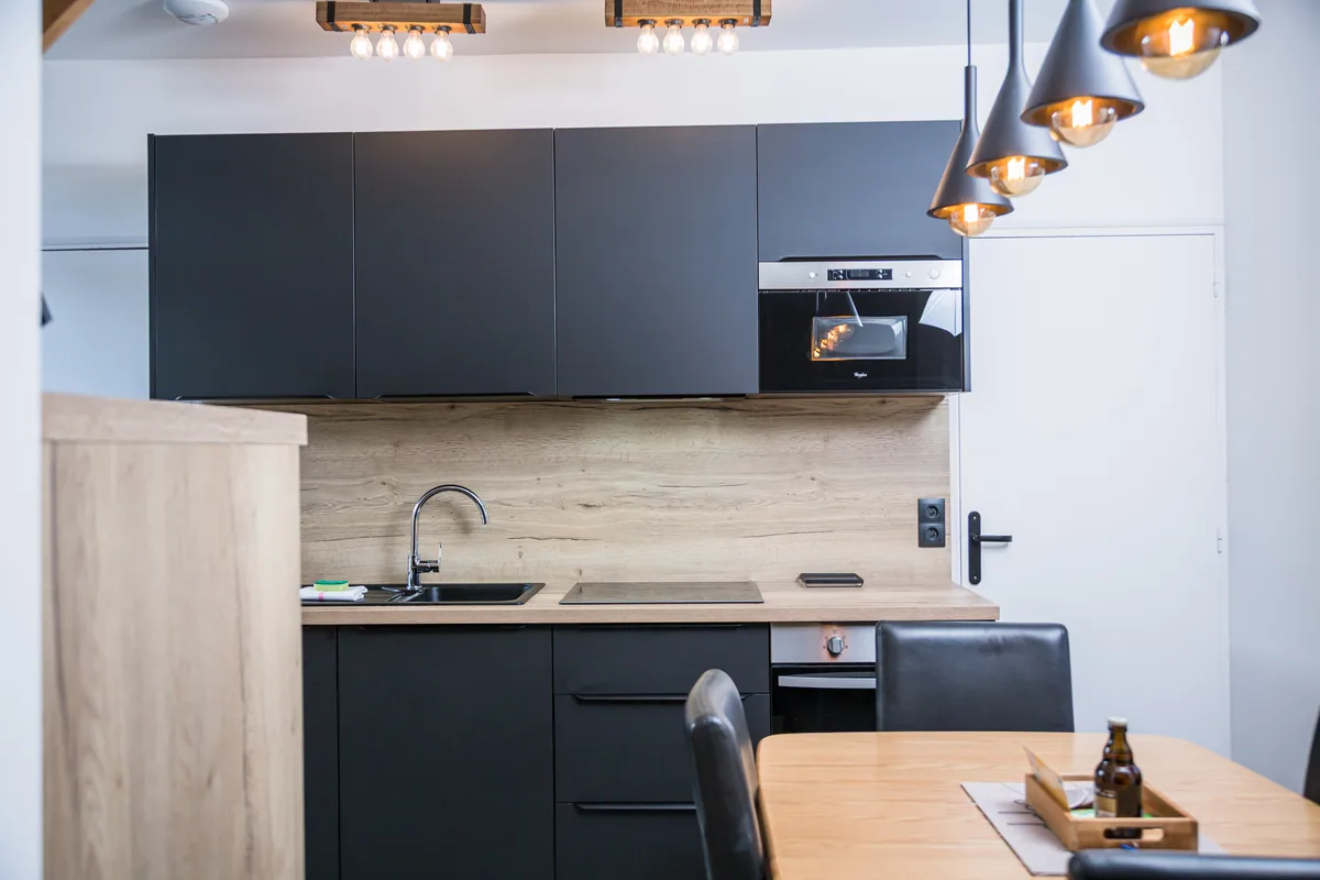 Maison La Vesée, l'appartement Heliconia, la cuisine vue de face avec la table chêne au premier plan