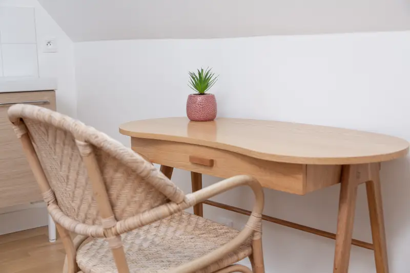 Maison La Vesée, l'appartement Heliconia, la chambre avec deux lits simples, vue rapprochée sur le bureau et la chaise en osier