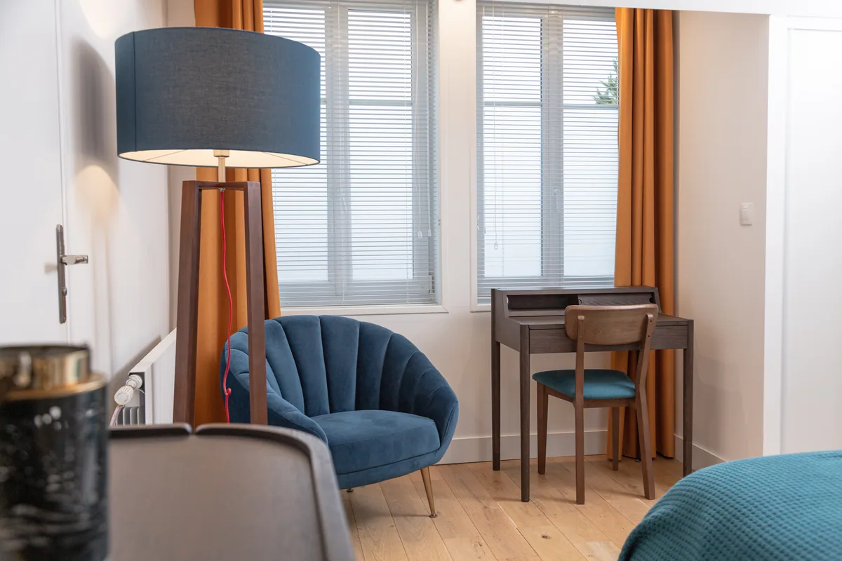 Maison La Vesée, l'appartement Heliconia, la suite parentale, vue sur le fauteuil bleu et le coin bureau
