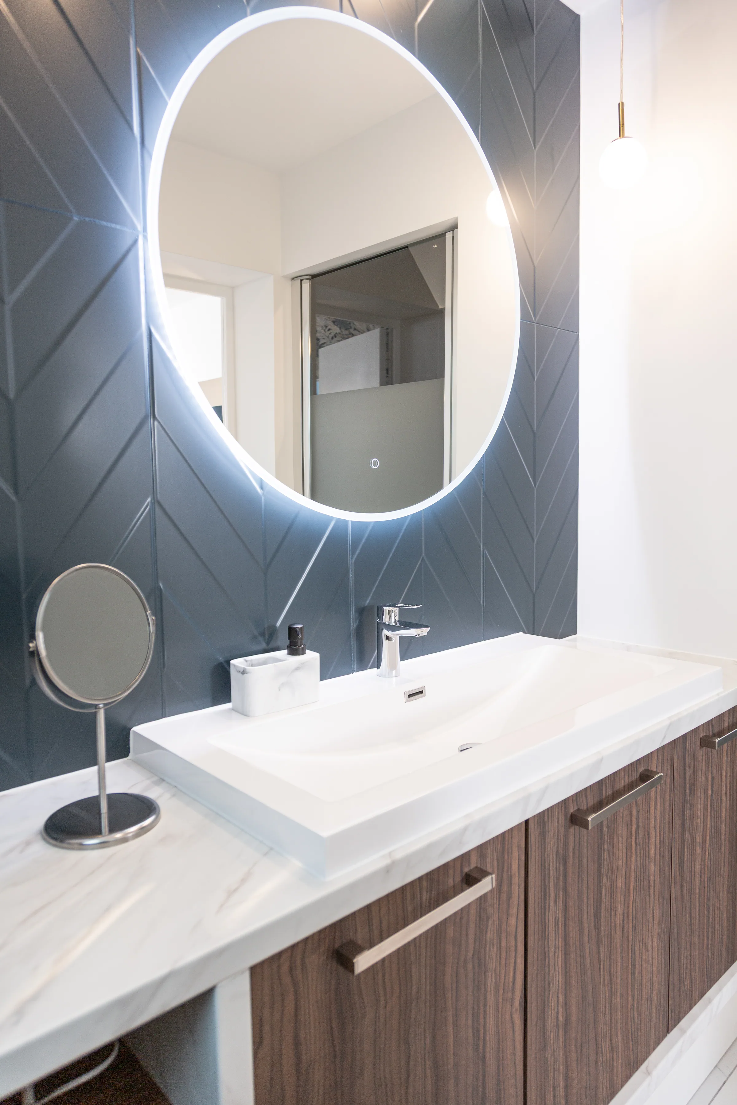 Maison La Vesée, l'appartement Heliconia, la suite parentale, la salle de douche attenante, vue d'ensemble sur meuble vasque et miroir éclairé