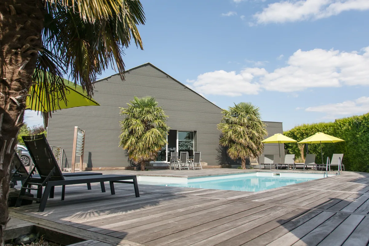 La piscine de Maison La Vesée, vue sur le bassin avec l'annexe en arrière-plan