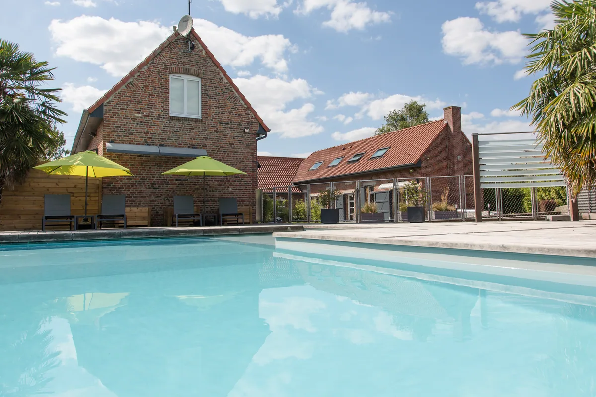 La piscine de Maison La Vesée, vue sur le bassin avec la Maison en arrière-plan