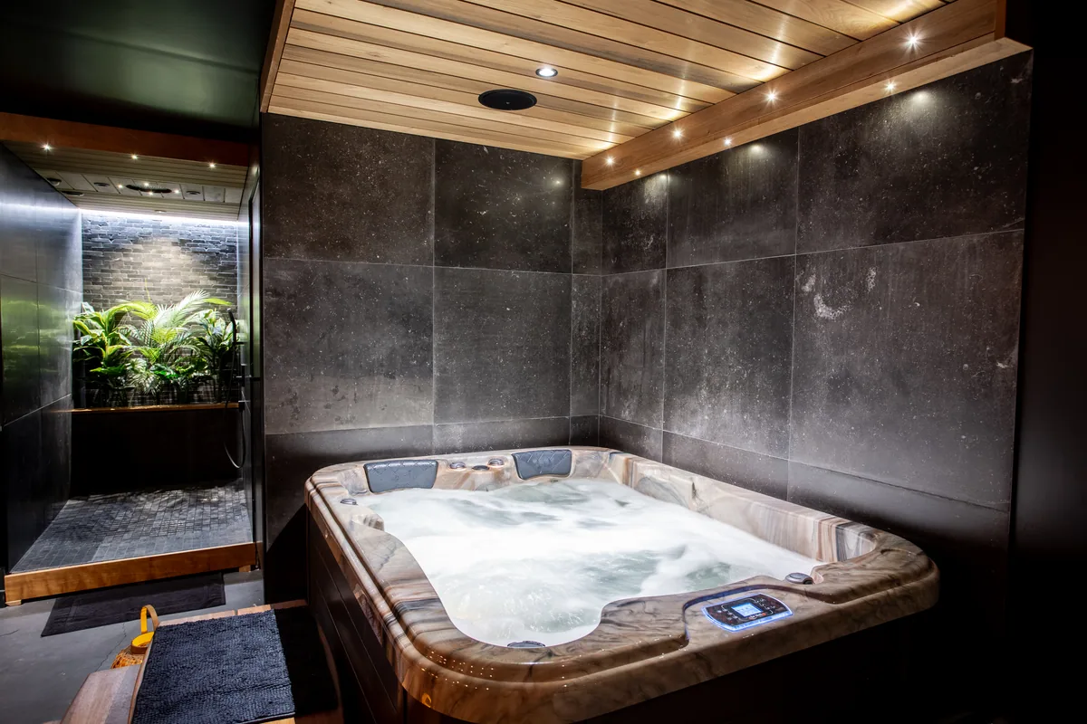 L'Espace bien-être de Maison La Vesée, le bain à remous avec la douche en arrière-plan