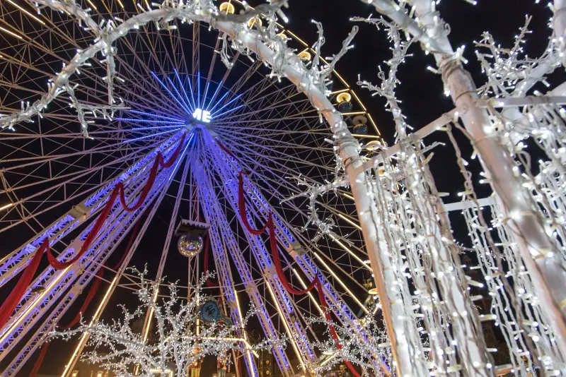 Ein Bogen aus weißem Licht vor dem Riesenrad