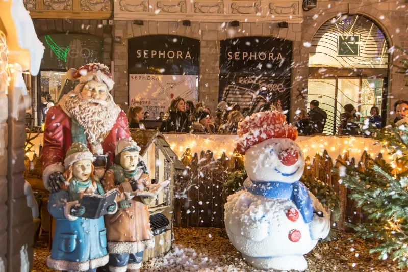 Dieselbe Dekoration unter Kunstschnee: Weihnachtsmann, Sänger und Schneemann