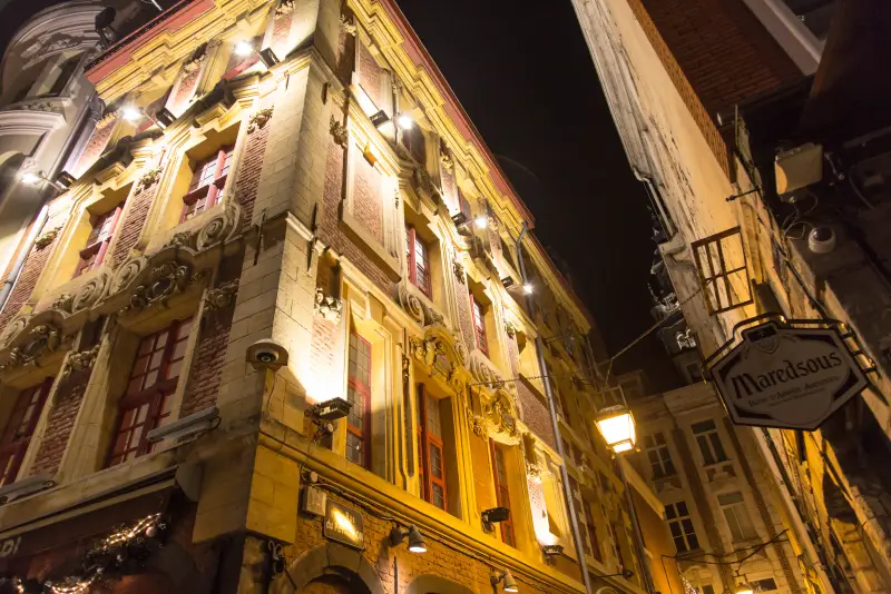 Eine beleuchtete historische Fassade und ein Brasserie-Schild, in einer Straße der Altstadt
